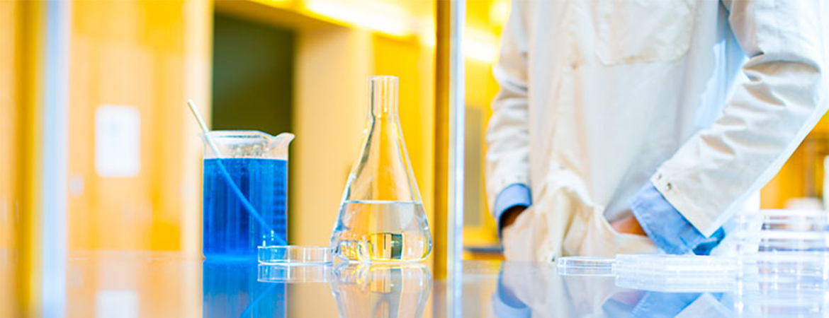 Researcher mixing solutions in a lab. 